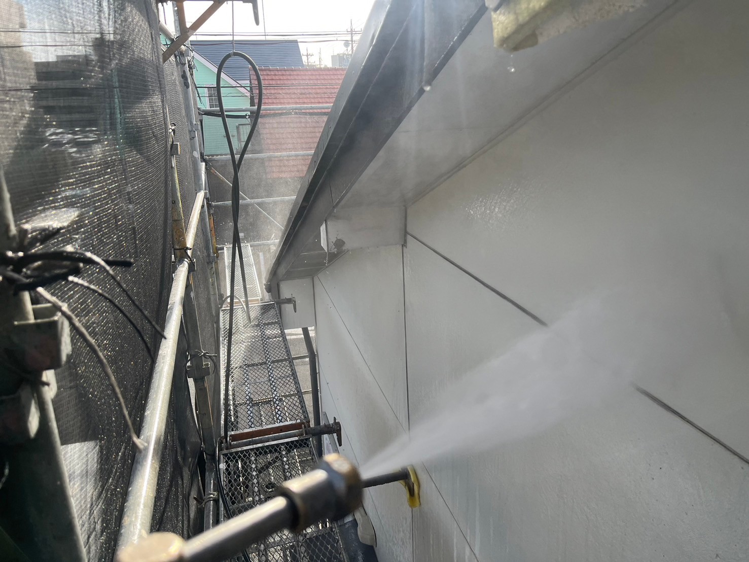 高圧洗浄を行い、塗装前に汚れやコケなどを洗浄しています。